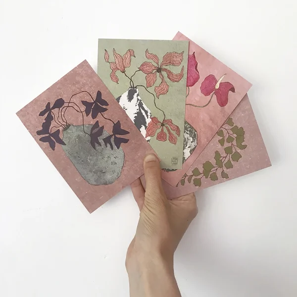 mano sosteniendo postales que muestran flores y plantas en jarrones cerámica - ilustración inspiración japonesa